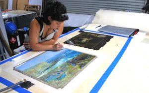 Oriana Montemurro, Art Conservator, working on the hot table lining a painting.