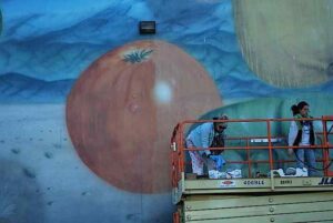 The process of water-damaged painting restoration for a mural depicting a tomato 