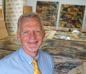 Scott Haskins, art conservator, with murals in his lab